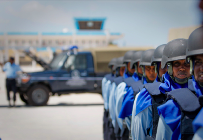 Military soldiers line up in front of vehicle